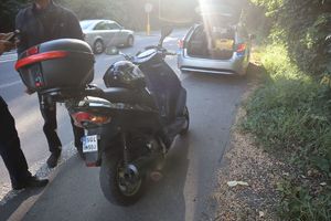Zdjęcie motocykla, radiowozu oraz policjanta i kontrolowanego mężczyznę