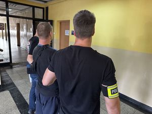 Zdjęcie zatrzymanego mężczyzny z policjantami