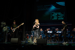 Zdjęcie wokalistki na scenie i policyjnej orkiestry