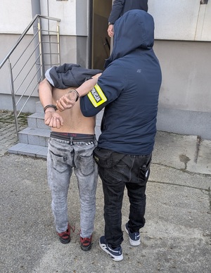 Zdjęcie policjanta prowadzącego zatrzymanego mężczyzny