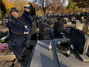 Zdjęcie policjantów podczas składania zniczy na gromach zasłużonych osób dla regionu