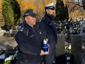 Zdjęcie policjantów podczas składania zniczy na gromach zasłużonych osób dla regionu