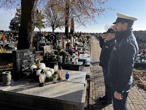 Zdjęcie policjantów podczas składania zniczy na gromach zasłużonych osób dla regionu