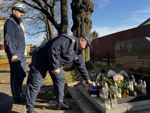 Zdjęcie policjantów podczas składania zniczy na gromach zasłużonych osób dla regionu