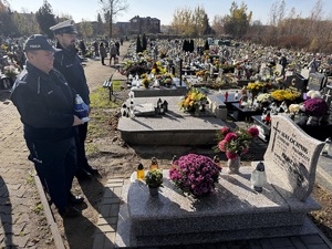 Zdjęcie policjantów podczas składania zniczy na gromach zasłużonych osób dla regionu