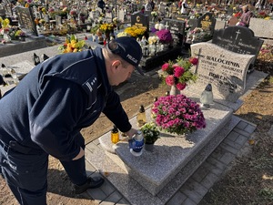 Zdjęcie policjantów podczas składania zniczy na gromach zasłużonych osób dla regionu
