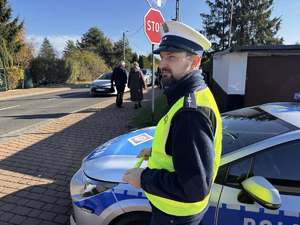 Zdjęcie policjanta podczas rozdawania odblasków