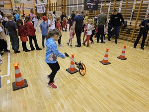 Zdjęcie policjantów oraz dzieci na hali sportowej podczas spotkania "Sportowy Mikołaj"
