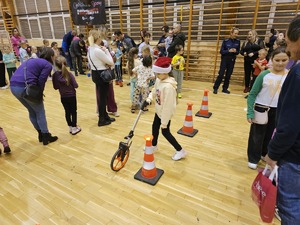 Zdjęcie policjantów oraz dzieci na hali sportowej podczas spotkania "Sportowy Mikołaj"