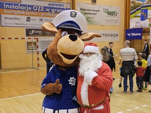 Zdjęcie policjantów oraz dzieci na hali sportowej podczas spotkania "Sportowy Mikołaj"