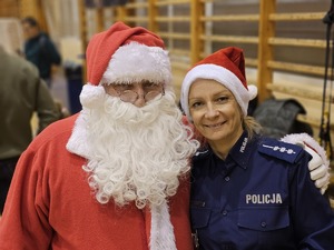 Zdjęcie policjantów oraz dzieci na hali sportowej podczas spotkania "Sportowy Mikołaj"