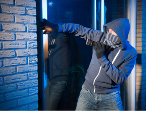 Zdjęcie zamaskowanego mężczyzny włamującego się do domu