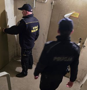 Zdjęcie policjanta oraz strażnika miejskiego podczas sprawdzania miejsc przebywania osób bezdomnych