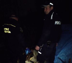Zdjęcie policjanta oraz strażnika miejskiego podczas sprawdzania miejsc przebywania osób bezdomnych