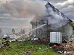 Zdjęcie strażaka gaszącego pożar domu