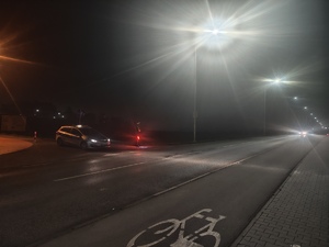 Radiowóz na zamglonej drodze