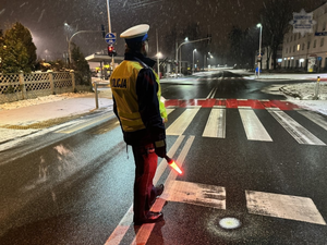 Zdjęcie przedstawia policjanta podczas kontroli stany trzeźwości kierujących