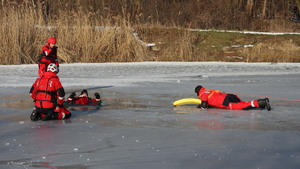 Zdjęcia policjantów z ćwiczeń na zamarzniętym zbiorniku wodnym wraz ze strażą pożarną, Wodnym Ochotniczym Pogotowiem Ratunkowym oraz Strażą Miejska