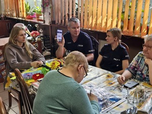 Zdjęcie policjantów oraz seniorów podczas spotkania w klubie seniora