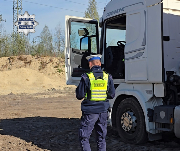 Policjant ubrany w kamizelkę odblaskową podczas kontroli ciężarówki