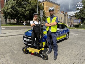 Zdjęcie policjantów przy hulajnodze i radiowozie