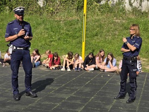 Policjanci oraz ratownik wodny, strażnik miejski podczas pogadanki z dziećmi