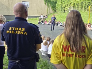 Policjanci oraz ratownik wodny, strażnik miejski podczas pogadanki z dziećmi