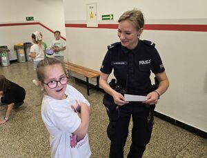 Policjanci oraz ratownik wodny, strażnik miejski podczas pogadanki z dziećmi