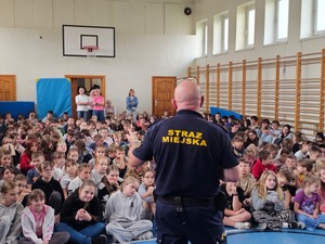 Policjanci oraz ratownik wodny, strażnik miejski podczas pogadanki z dziećmi