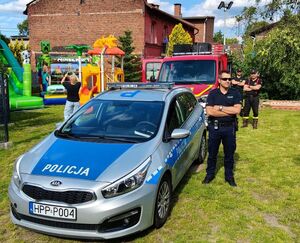 Policjanci oraz ratownik wodny, strażnik miejski podczas pogadanki z dziećmi