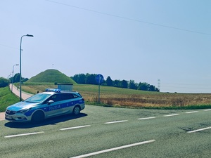 Radiowóz. W tle Kopiec Wyzwolenia w Piekarach Śląskich w upalny dzień.