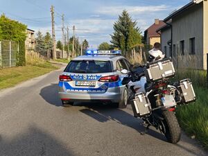 Zdjęcie policyjnego radiowozu oraz zatrzymanego motocykla